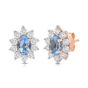 Jewelili 14K Rose Gold Over Sterling Sliver Oval Genuine Swiss Blue Topaz and 1/20 CTTW Natural White Round Diamond Cluster Stud Earrings